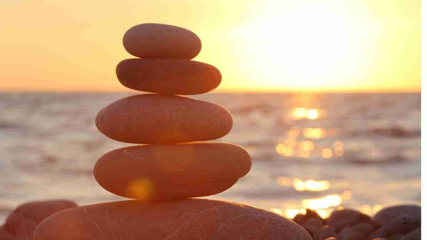 Balanced stones by the sea during golden sunset.