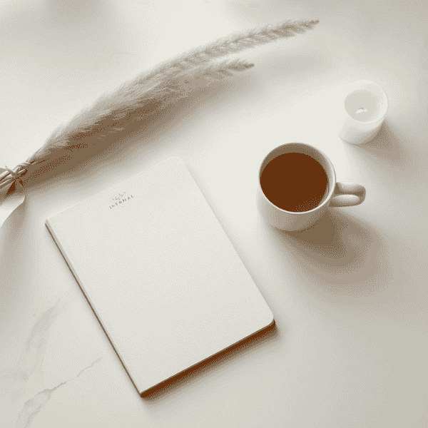 Minimal workspace with journal, candle, and tea creating a calm environment for daily spiritual practice and mindfulness